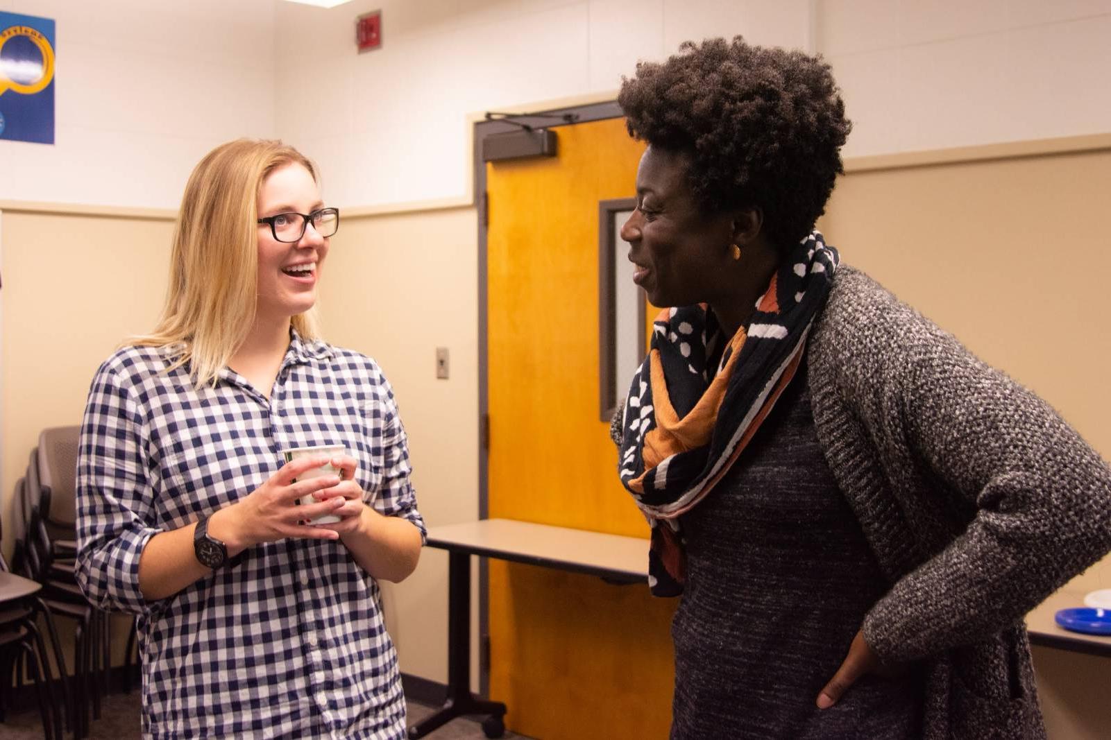 A picture of a professor actively listening as a student speaks.