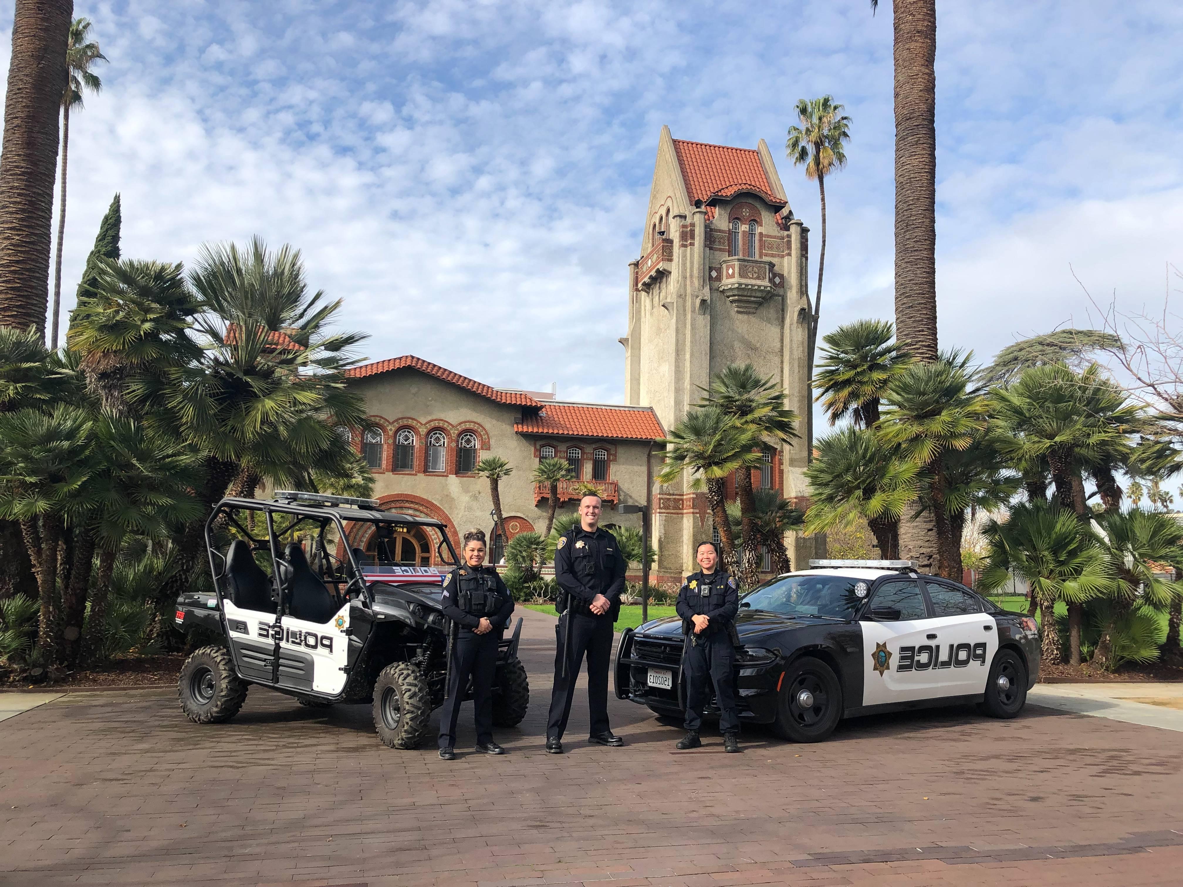 Male university police 官 stands by his car smiling