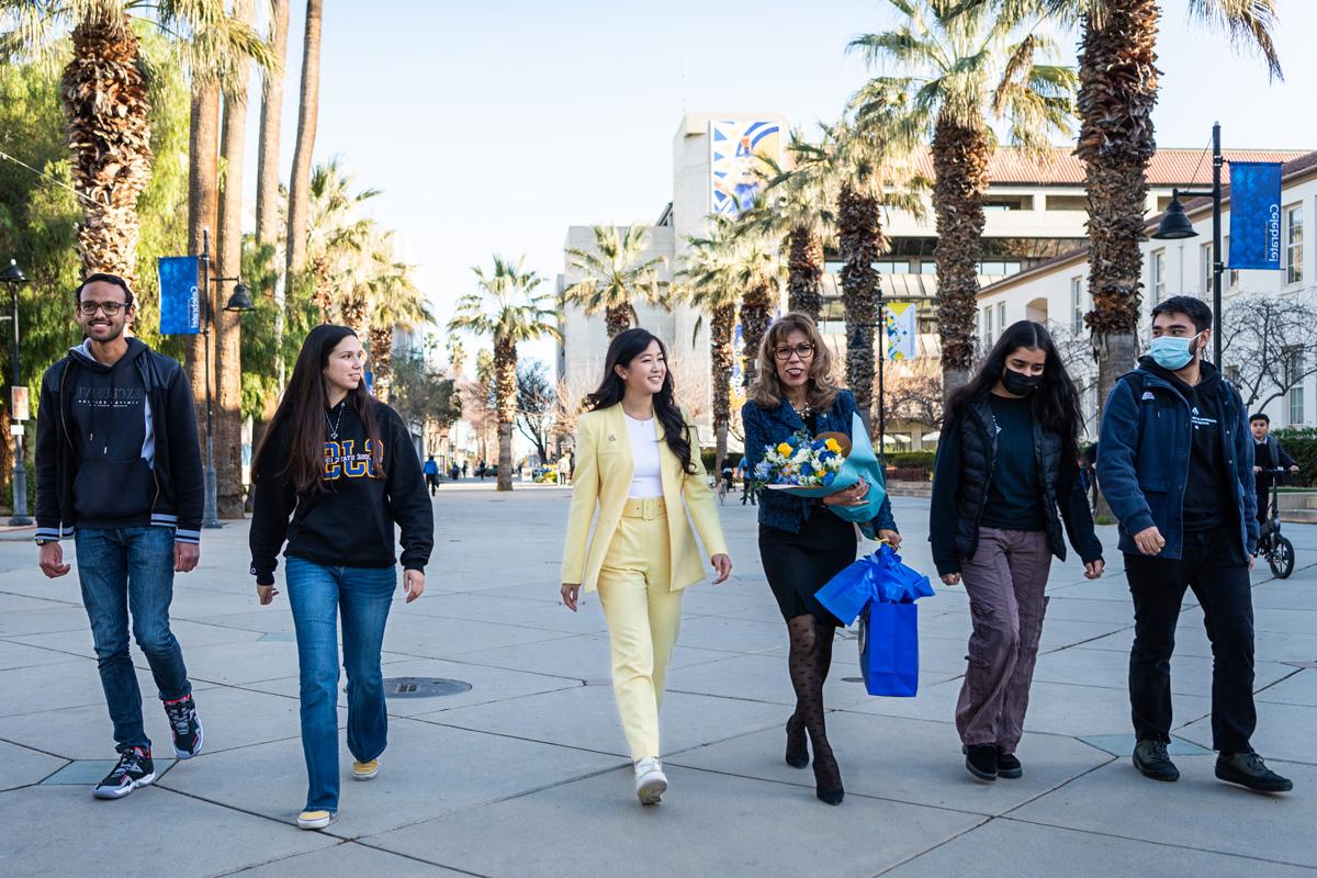 President Teniente-Matson walking down the Paseo with students.