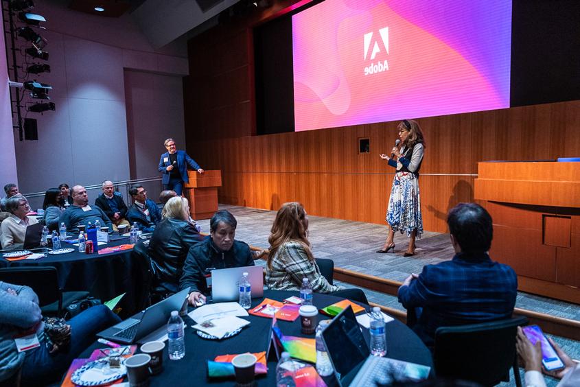 President Teniente-Matson standing on a stage at the Adobe headquarters.