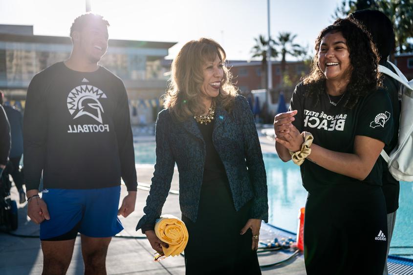 President Teniente-Matson posing with student-athletes near the pool.