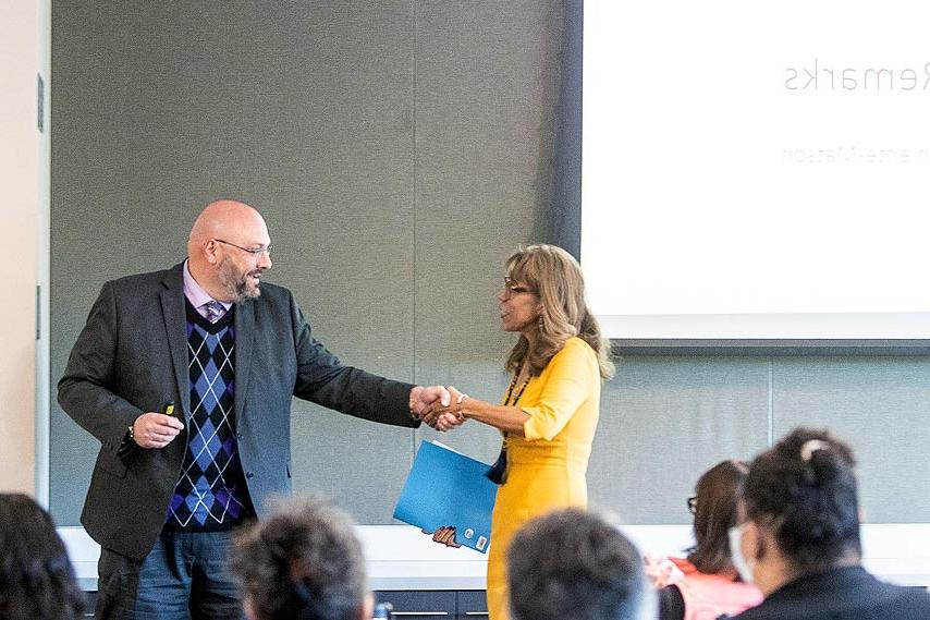 President Teniente-Matson shaking hands with the dean of College of Business.