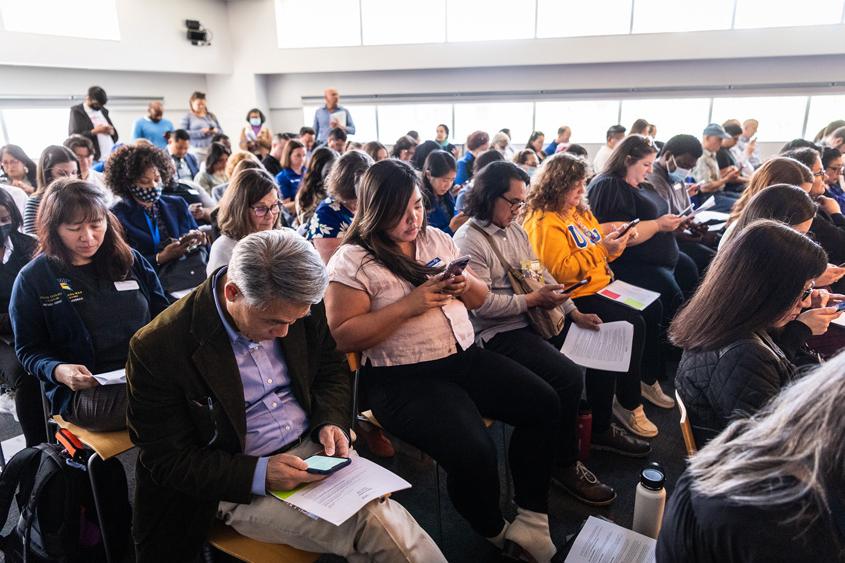 Participants sitting in a room together taking a survery during the summit.