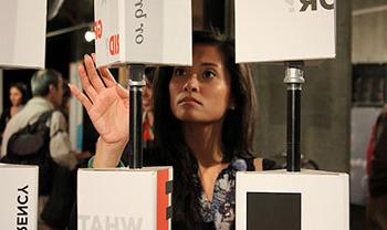 person turns an interactive shape at a library exhibit