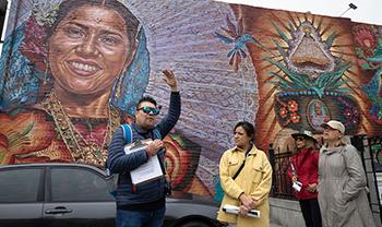 person gives tour near mural of ancestor